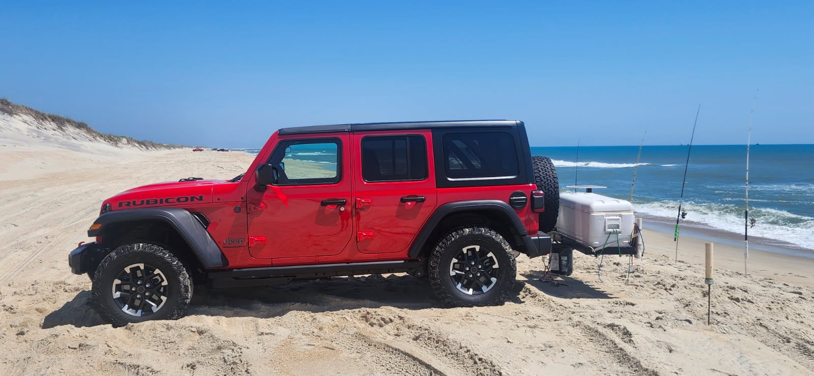 Red Jeep Wrangler Rubicon rental beach driving on the Outer Banks with a fishing cart